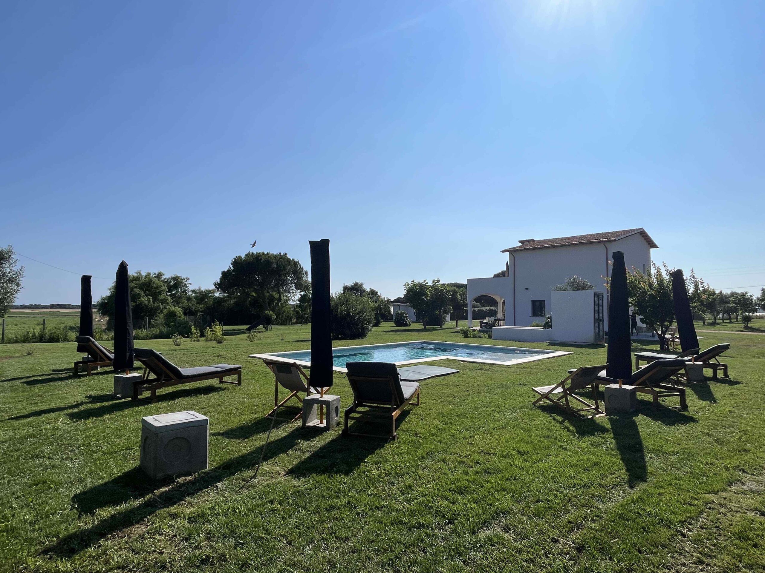 View of the garden and swimming pool with a scenic view of the main villa at Il Podere Bianco